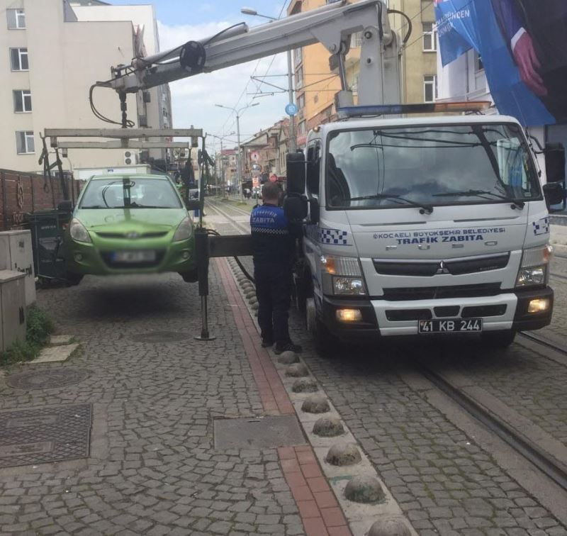 Tramvay yoluna park edilen araçlar çekiliyor
